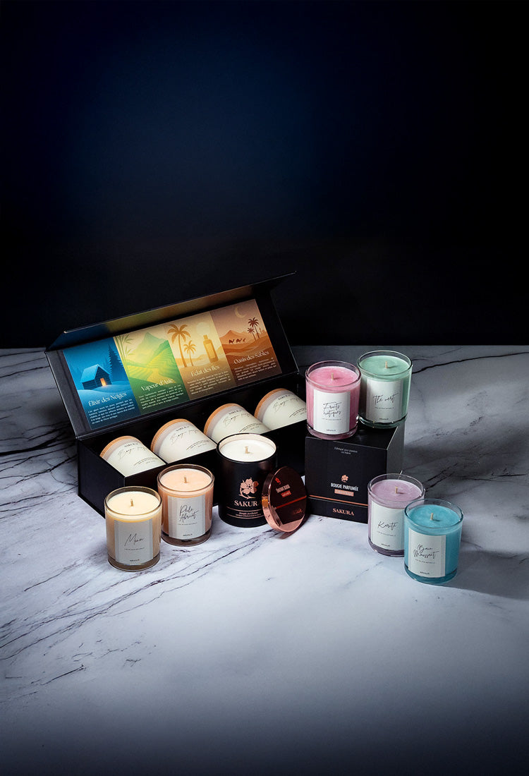 Coffret de bougies parfumées artisanales Sakura comprenant plusieurs fragrances, accompagné des collections Ikigai et Hanami, présenté sur un fond marbré – fabrication suisse en cire naturelle.